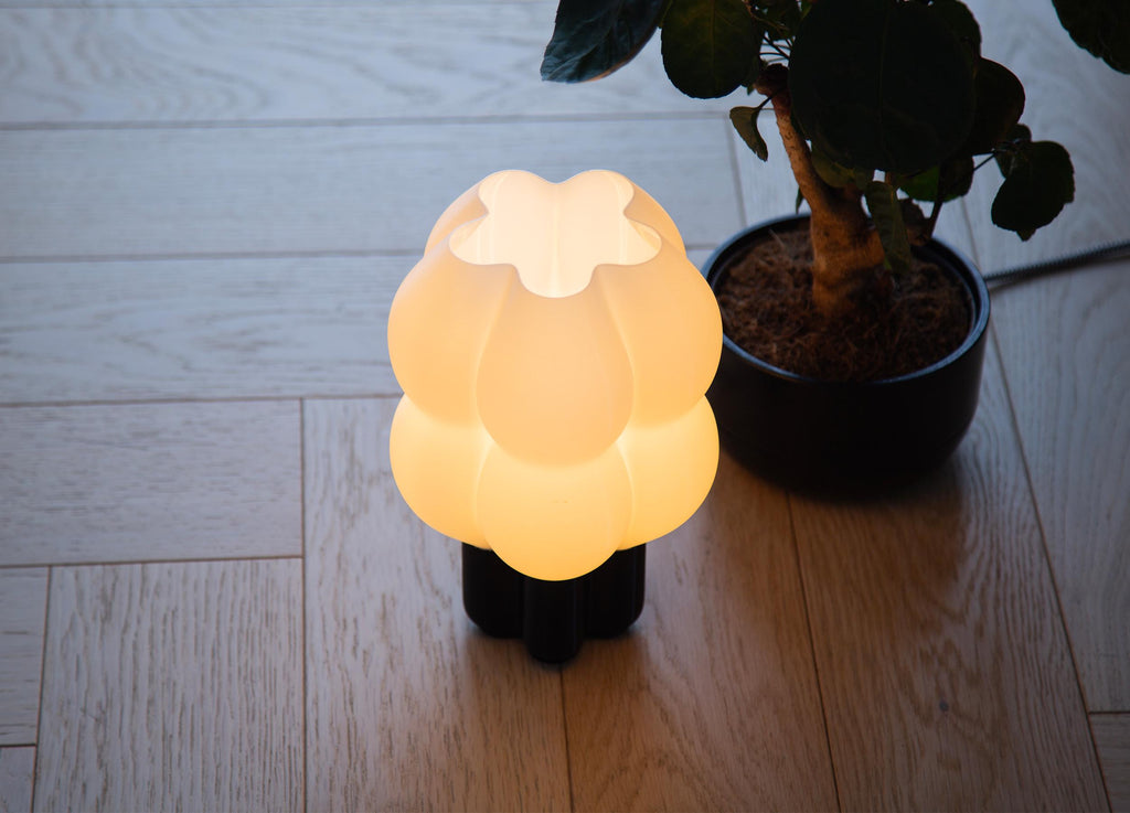A close-up of a glowing dome-shaped lampshade made of warm translucent material, with centered text describing high-precision printing and light diffusion.