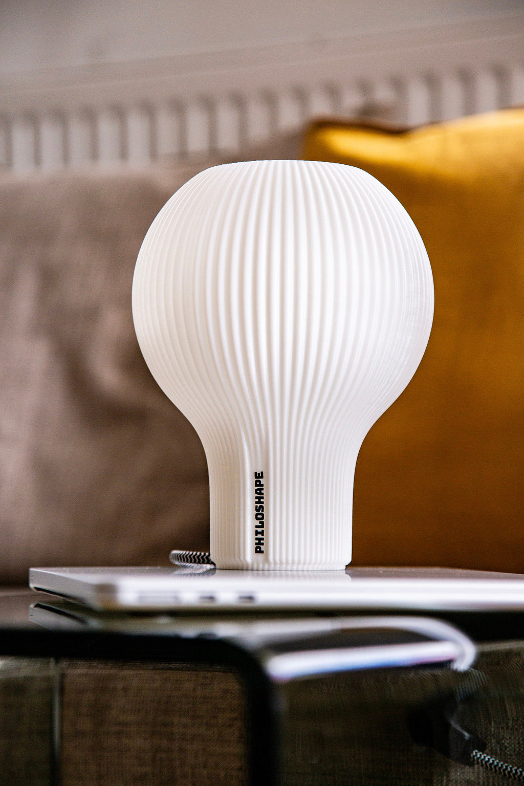 A ribbed translucent white glass lampshade with a black fluted base, displayed on a white surface against a neutral gray background.