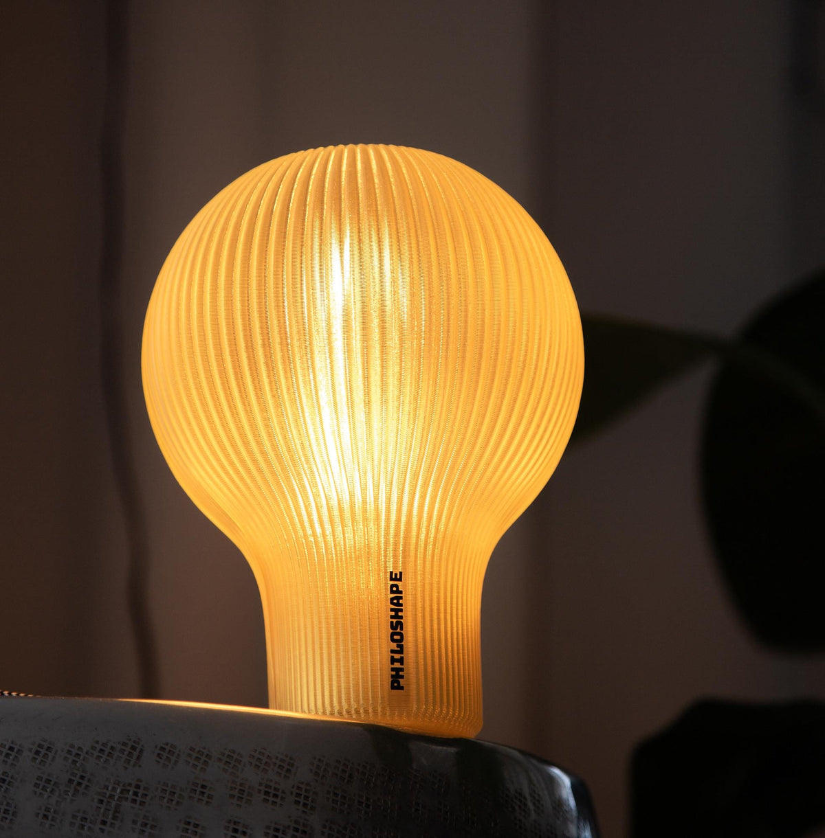 A close-up of a glowing dome-shaped lampshade made of warm translucent material, with centered text describing high-precision printing and light diffusion.