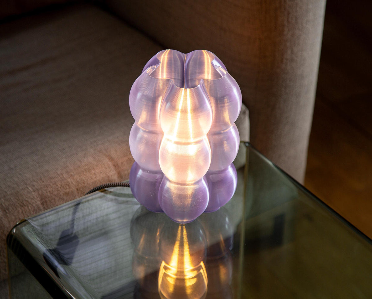 A close-up of a glowing dome-shaped lampshade made of warm translucent material, with centered text describing high-precision printing and light diffusion.