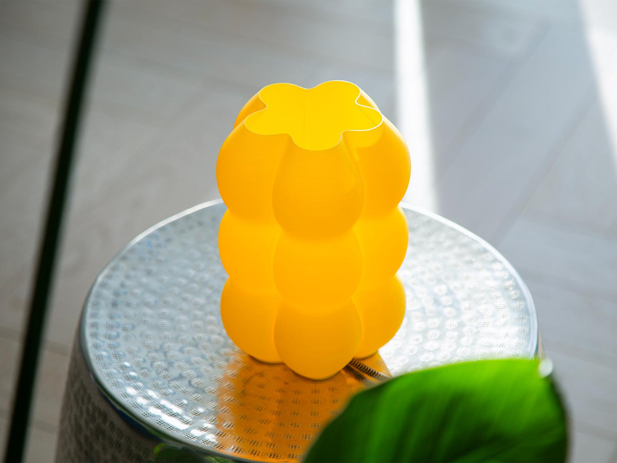 Close-up of a ribbed translucent glass shade or vase with warm yellow light glowing through the center.